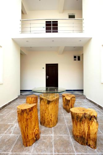 a room with a glass table and three logs at Thiru Pavilion Retreat in Mahabalipuram