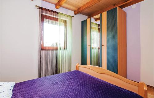 Podorjakにある1 Bedroom Lovely Apartment In Krusevoのベッドルーム(紫色のベッド1台、窓付)