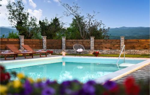 a swimming pool with two chairs and a table at 4 Bedroom Gorgeous Home In Hrvace in Hrvace