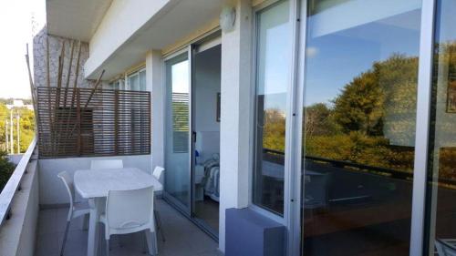 un balcón con una mesa y sillas blancas y una ventana a Punta vacaciones en Las Gaviotas