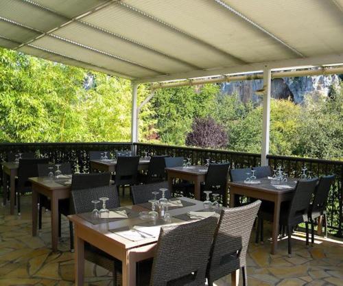 a dining area with tables and chairs at Hôtel Restaurant Les Falaises in Bouziès