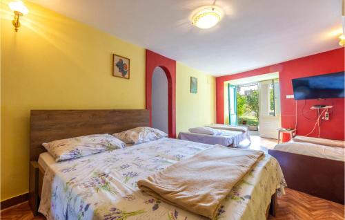 een slaapkamer met een groot bed en gele en rode muren bij Lovely Apartment In Omis With Kitchen in Omiš
