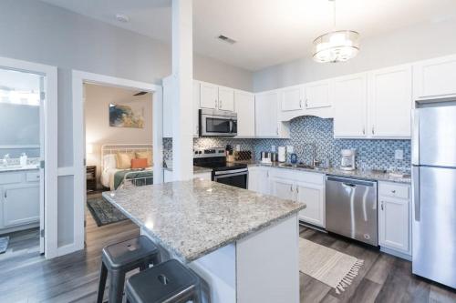 a kitchen with white cabinets and a counter top at Sanctuary Co 204 Loft Downtown Johnson City in Johnson City