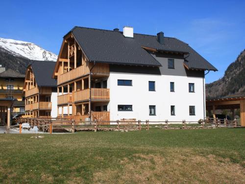 a large white building with a black roof at Wooden chalet in Mauterndorf near Cross Country Meadows in Mauterndorf