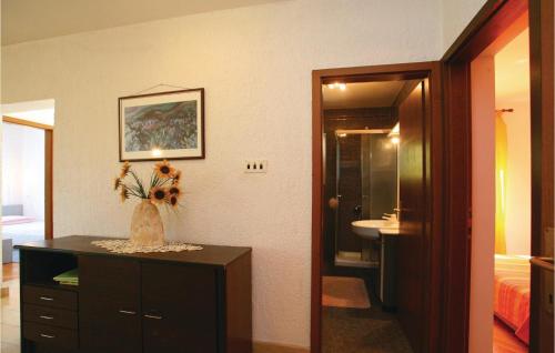 a room with a vase with flowers on a dresser at Nice Apartment In Labin With Outdoor Swimming Pool in Ravni