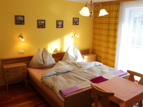 a small bedroom with a bed and a table at Apartment in Rennweg am Katschberg near ski area in Rennweg