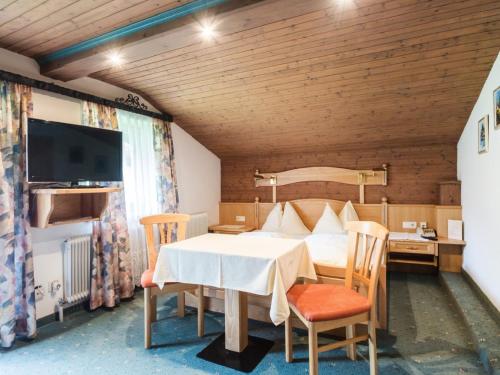 クライナルにあるSimplistic Apartment in Kleinar near Cross Country Skiingのベッドルーム1室(ベッド1台、テーブル、椅子付)