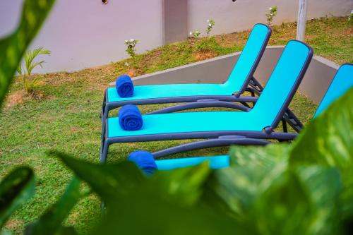 a blue chair sitting on the grass in a yard at Hidden Valley Residence in Au Cap