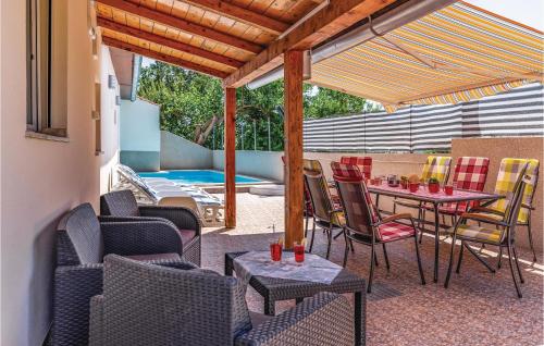 un patio con mesa, sillas y piscina en 5 Bedroom Lovely Home In Pavicini, en Pavicini