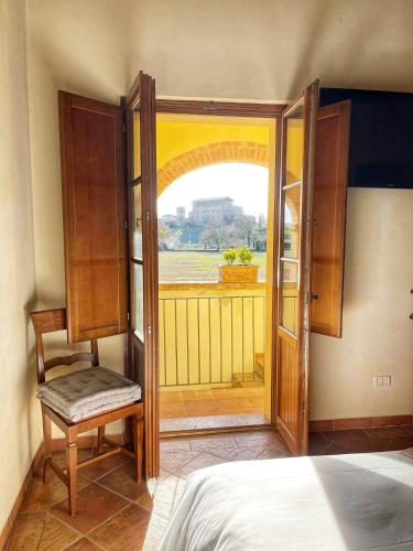 a bedroom with an open door with a bed and a window at Hotel More di Cuna in Monteroni dʼArbia