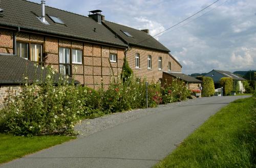 an empty road in front of a brick house at Appartement Hoeve Espewey - Leisure only in Hombourg