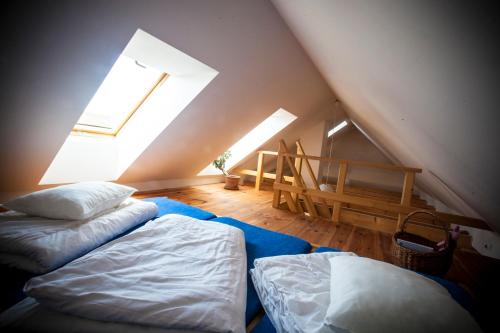 StříbřecにあるPenzion Mníšekのベッド2台と窓が備わる屋根裏部屋です。