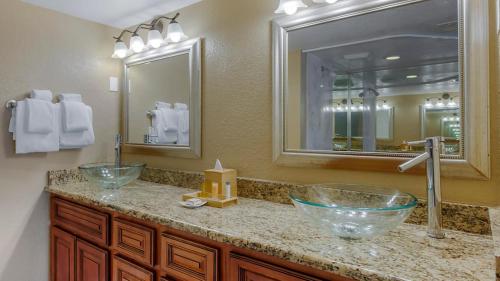 Bluegreen Vacations Orlando's Sunshine Resort في أورلاندو: حمام به حوضين للغسيل ومرآة
