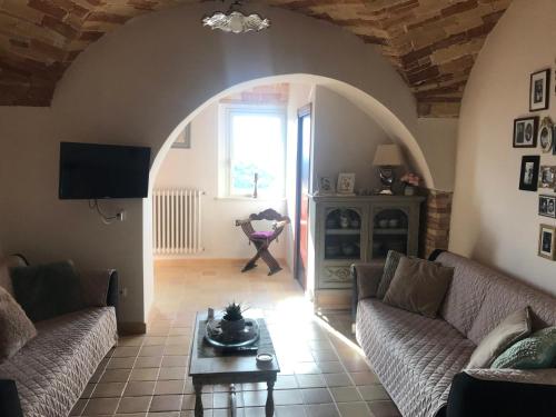 Charmante vakantiewoning 'Casa Di Tonno' في لوريتو أبروتينو: غرفة معيشة مع كنبتين وطاولة