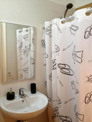 a bathroom with a sink and a shower curtain at Cal Gaitero in Monistrol