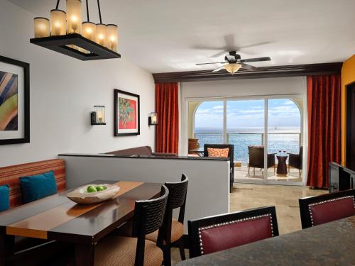 a dining room with a table and chairs and the ocean at Sirena del Mar by Vacation Club Rentals in Cabo San Lucas