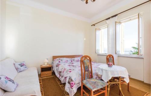 sypialnia z łóżkiem, stołem i krzesłami w obiekcie Stunning Apartment In Lovran With Kitchen w mieście Lovran