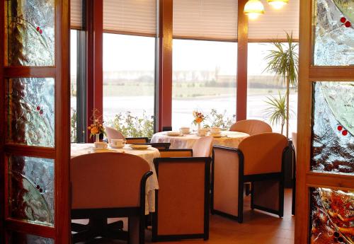 a dining room with tables and chairs and windows at Hotel Ristorante SASSO in Bovolone
