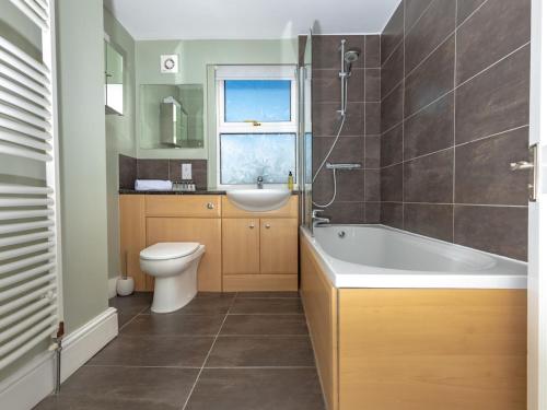 a bathroom with a tub and a toilet and a sink at Pass the Keys 3 bedroom home within walking distance of town in Shrewsbury