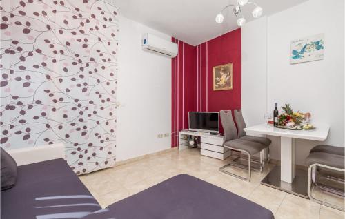 a living room with a red wall and a table at Stunning Apartment In Vrh With 1 Bedrooms, Wifi And Outdoor Swimming Pool in Vrh