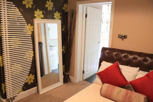 a living room with a mirror and a couch at Skylark Guest House in Hounslow