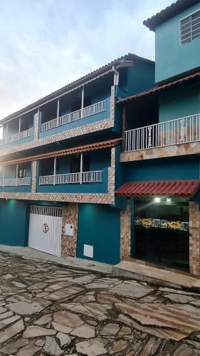 um edifício azul com duas varandas do lado em Pousada Serra Mística em São Tomé das Letras