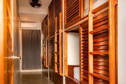 a bedroom with wooden walls and a bunk bed at Che Bacalar Hostel & Bar Adults Only in Bacalar