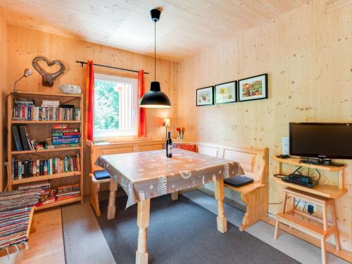 a dining room with a table and a tv at Detached wooden chalet in Stadl an der Mur Styria facing south with sauna in Stadl an der Mur