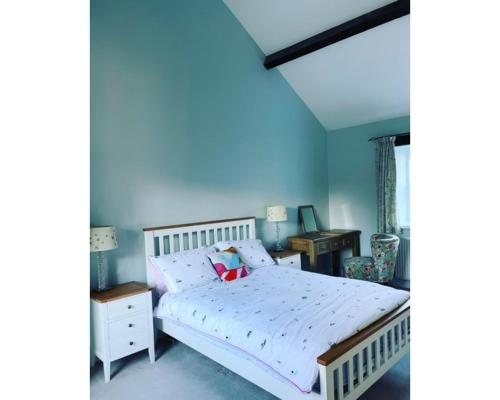 a bedroom with a white bed and a desk at Swallow Cottage in Ripon