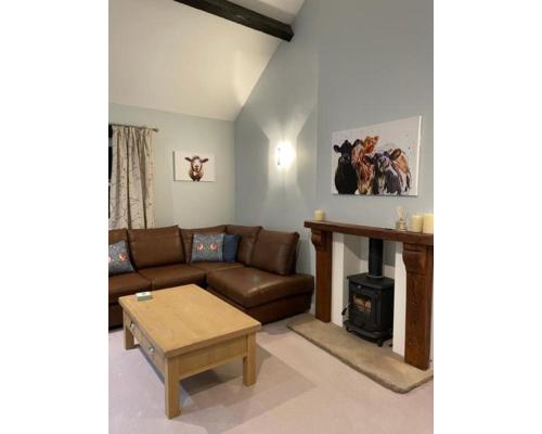 a living room with a couch and a fireplace at Swallow Cottage in Ripon