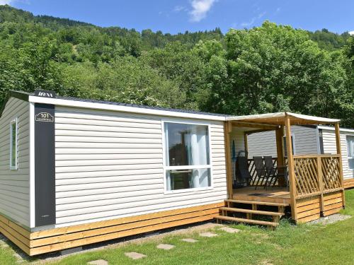a mobile home with a porch and a deck at Mobile home in Sachsenburg Carinthia with pool in Sachsenburg