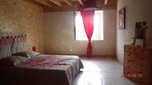- une chambre avec un lit et une fenêtre avec un rideau rouge dans l'établissement Au Nid d'hirondelles, à Saint-André-de-Chalençon