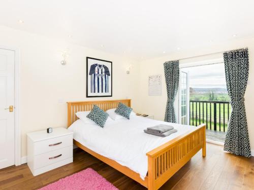 a bedroom with a large bed and a balcony at Pass the Keys SPACIOUS Modern 5 Bed, Sleeps up to 12 & Parking in Warwick