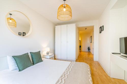 Schlafzimmer mit einem weißen Bett und einem Spiegel in der Unterkunft Simplon 10 - Lausanne Gare in Lausanne