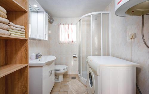 La salle de bains est pourvue d'un lavabo et d'un lave-linge. dans l'établissement Stunning Home In Cere With 2 Bedrooms, Wifi And Outdoor Swimming Pool, à Santalezi