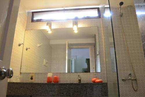 baño con espejo grande y lavabo en Posada del Gobernador, en Colonia del Sacramento