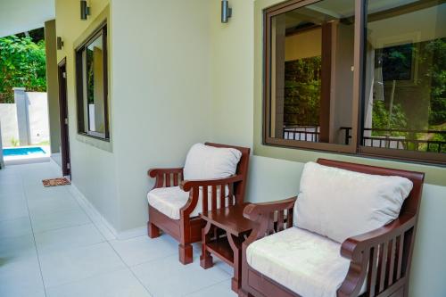 a porch with two chairs and a mirror at Hidden Valley Residence in Au Cap