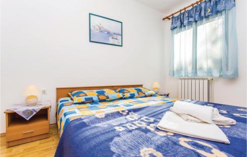 een slaapkamer met een bed met een blauw dekbed bij 1 Bedroom Awesome Apartment In Malinska in Malinska