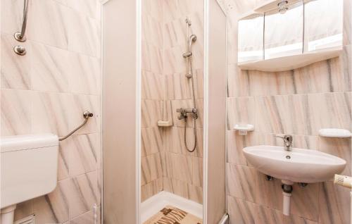 een badkamer met een douche, een wastafel en een toilet bij 1 Bedroom Awesome Apartment In Malinska in Malinska