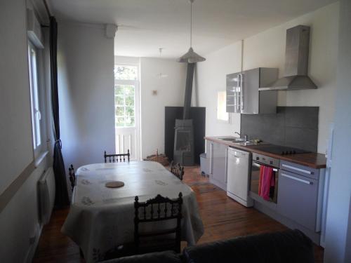 a kitchen with a table with a white table cloth at Gîte d'Airaines in Airaines