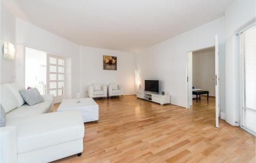 a living room with white furniture and a wooden floor at Nice Home In Vodice With Kitchen in Vodice