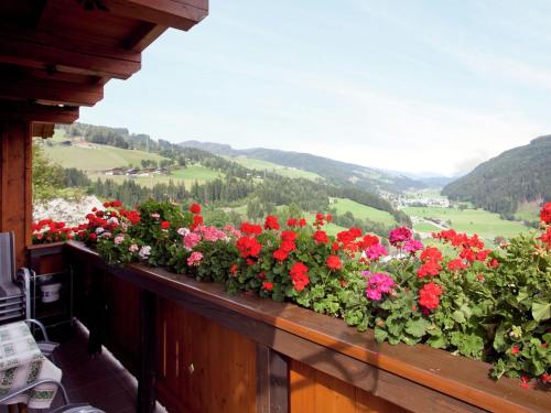 einen Balkon mit Blumen auf dem Felsvorsprung eines Hauses in der Unterkunft Sunny holiday flat with balcony in Wagrain