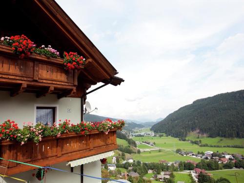 a building with flowers on a balcony with a valley at Sunny holiday flat with balcony in Wagrain