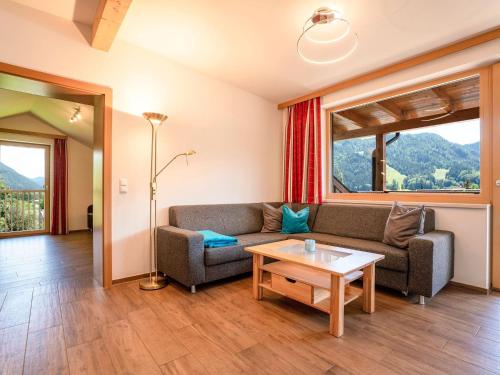 een woonkamer met een bank en een tafel bij Apartment directly on the Weissensee in Carinthia in Weissensee