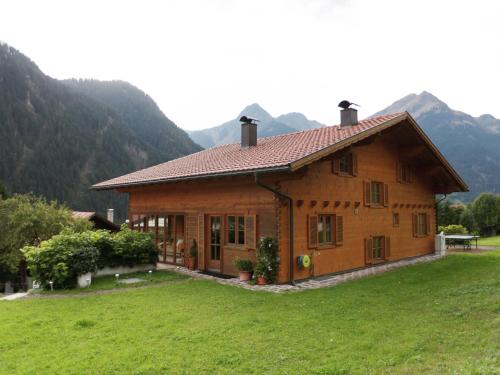 ザンクト・ガレンキルヒにあるApartment in Sankt Gallenkirch with terraceの山々を背景にした小さな木造家屋