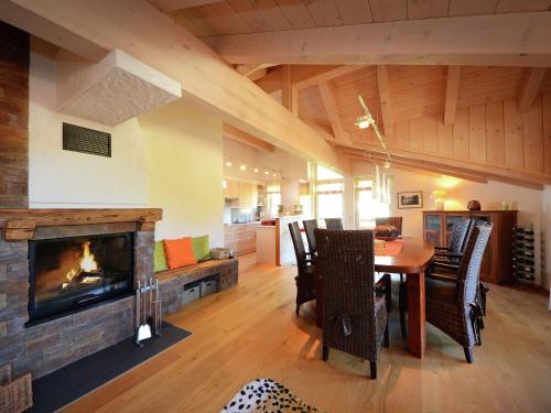 a living room with a fireplace and a table and chairs at Apartment near the ski area in Leogang