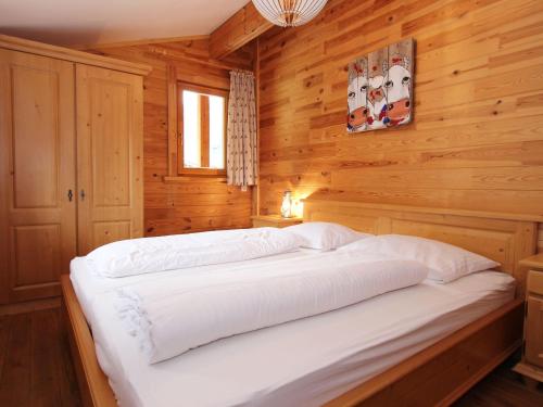 クリムルにあるWooden Chalet in Krimml Salzburg with garden grillの木製の部屋に大型ベッドが備わるベッドルーム1室が備わります。