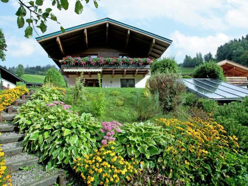 a garden with flowers in front of a building at Apartment near the ski area in Saalbach Hinterglemm