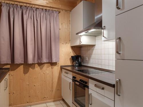 a small kitchen with white cabinets and a window at Chalet in Styria near Kreischberg Ski in Sankt Georgen ob Murau