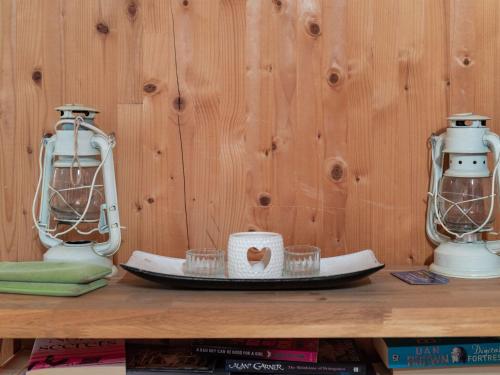 two lanterns sitting on top of a shelf with books at Chalet in Styria near Kreischberg Ski in Sankt Georgen ob Murau
